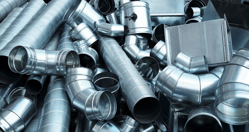 Pile of pipes and parts for duct systems. Industrial ventilation